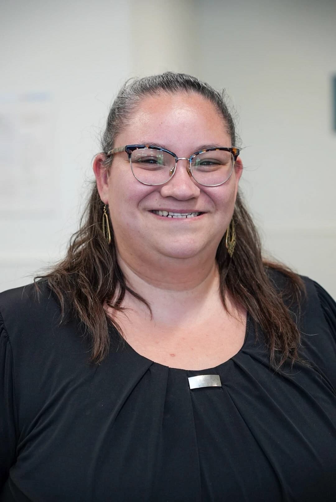Crystal, smiling, in glasses and a black top